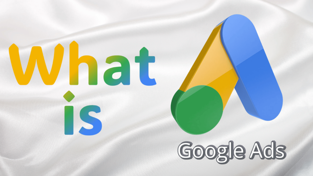 What is Google Ads' with the Google Ads logo. The words 'What' and 'is' are in a colorful gradient resembling Google's brand colors, and the background is a smooth, white satin fabric.